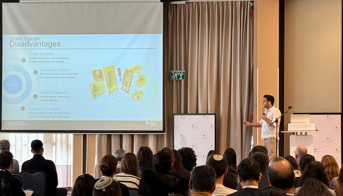 Daniel Lahav presenting at a conference, gesturing at a slide before a full audience
